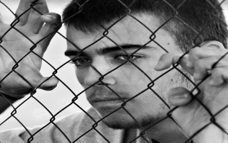Teenager behind a wired fence. Black and white photo